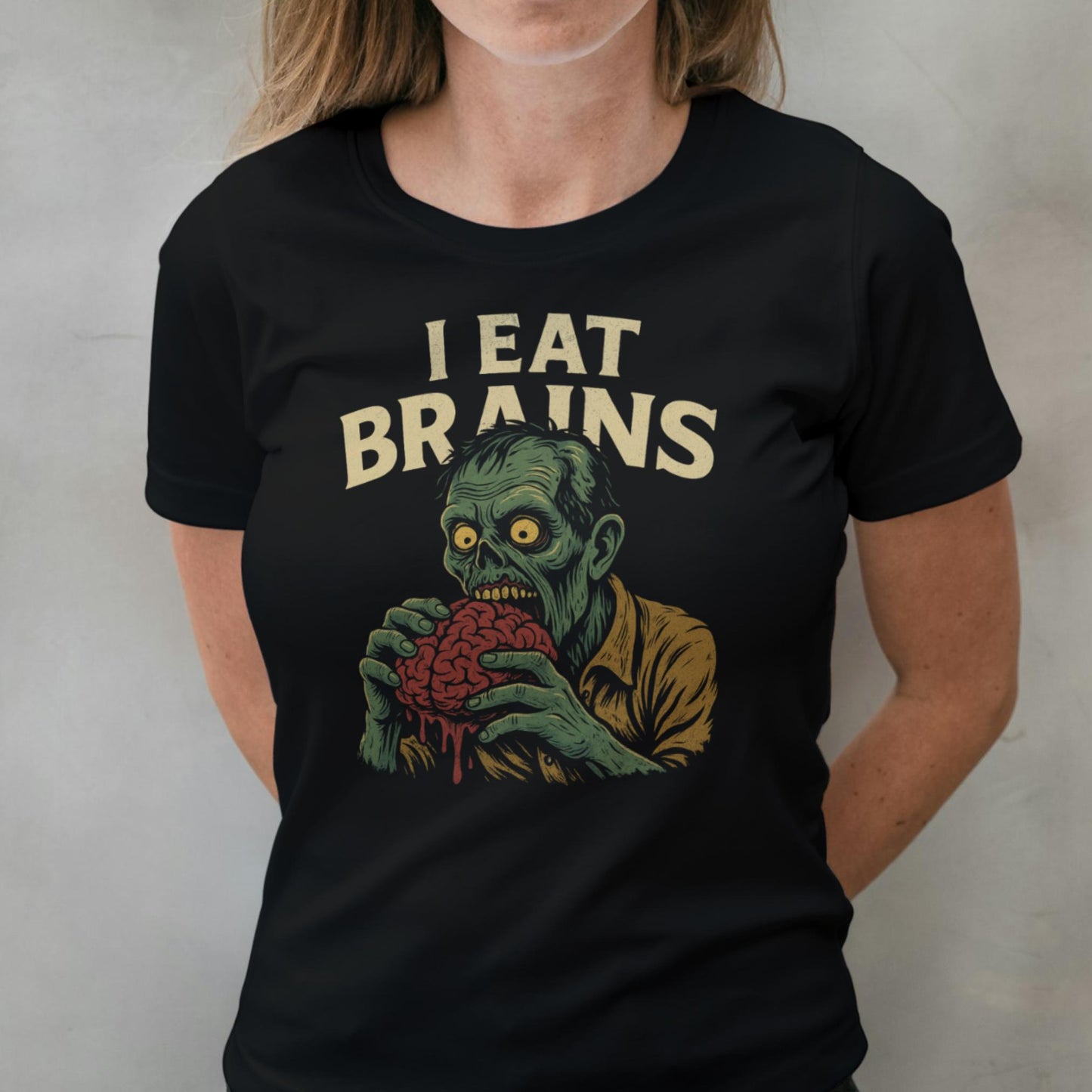 Person wearing a black t-shirt with a graphic of a zombie holding a brain and the text 'I Eat Brains'.