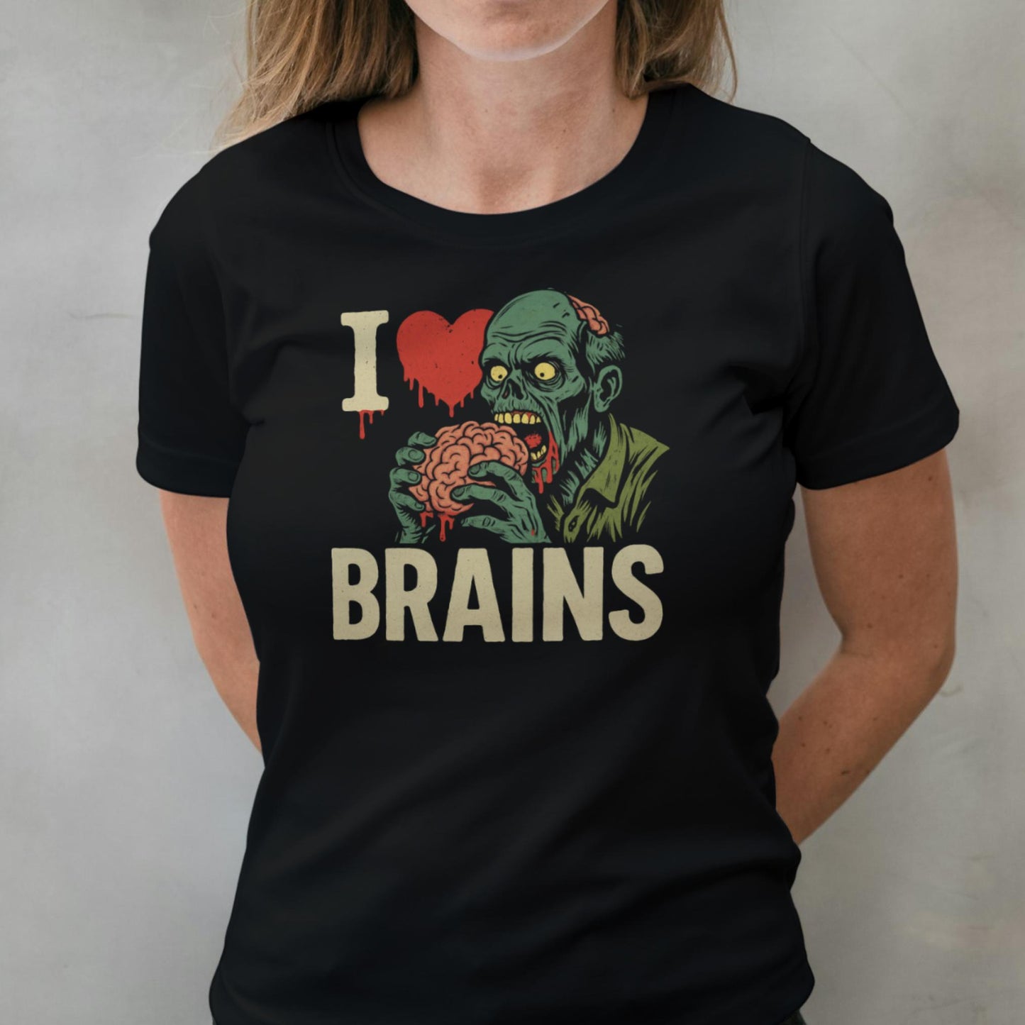 Person wearing a black t-shirt with a graphic design of a zombie holding a brain and 'I ❤️ BRAINS' text.