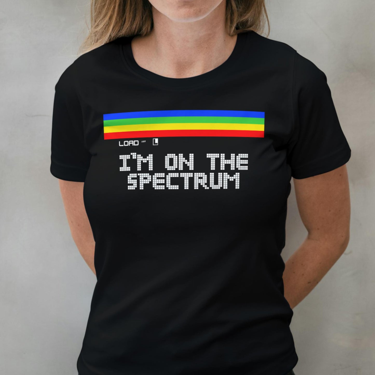 Person wearing a black t-shirt with a rainbow design and text on a plain background
