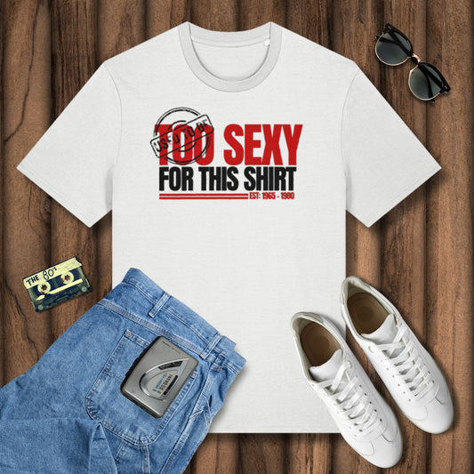 White t-shirt with 'Too Sexy for This Shirt' text, blue jeans, white sneakers, and sunglasses on a wooden surface.