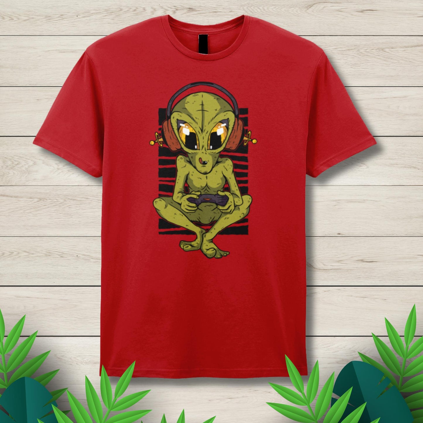 Red t-shirt with a green alien graphic on a wooden surface