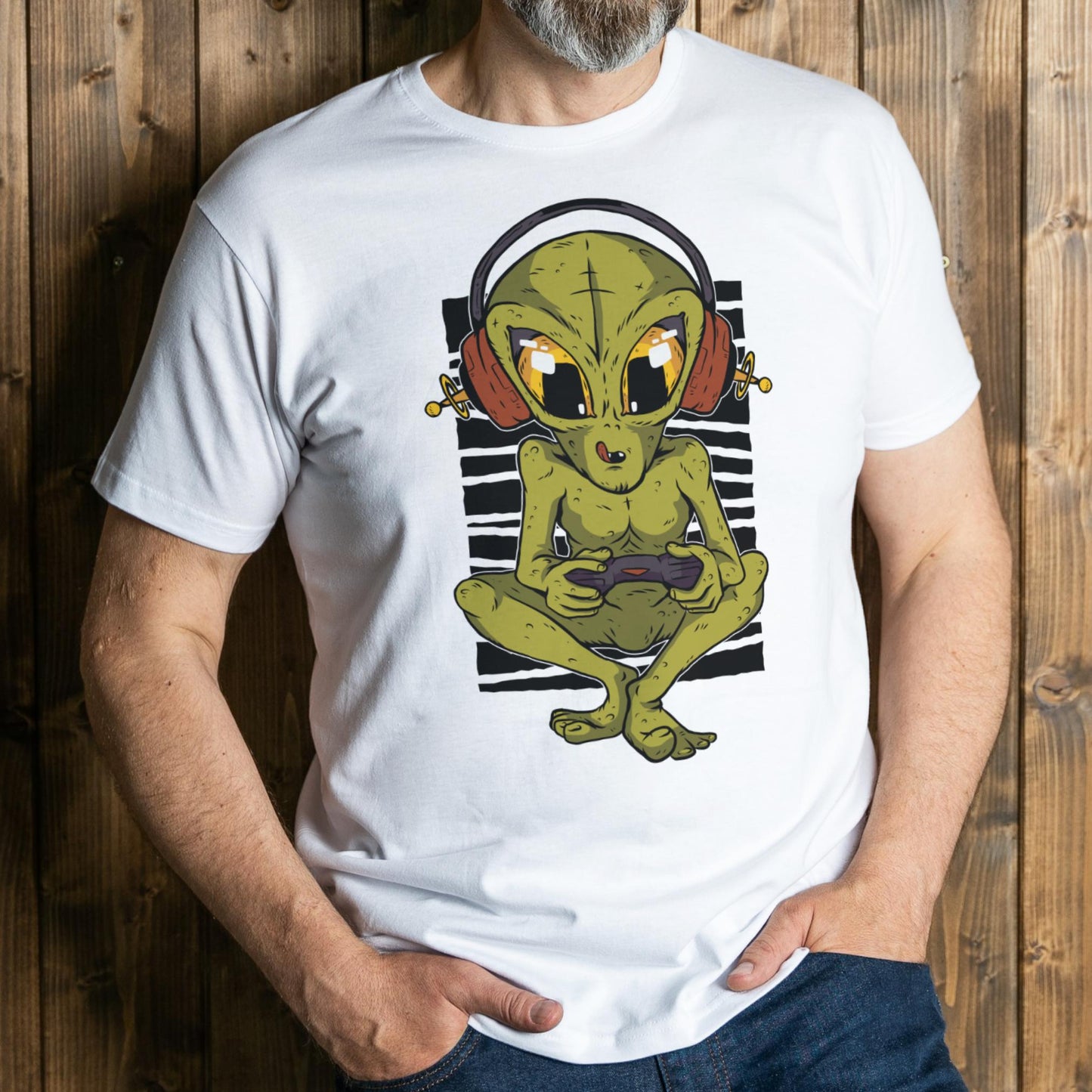 Person wearing a white t-shirt with an alien graphic design against a wooden background