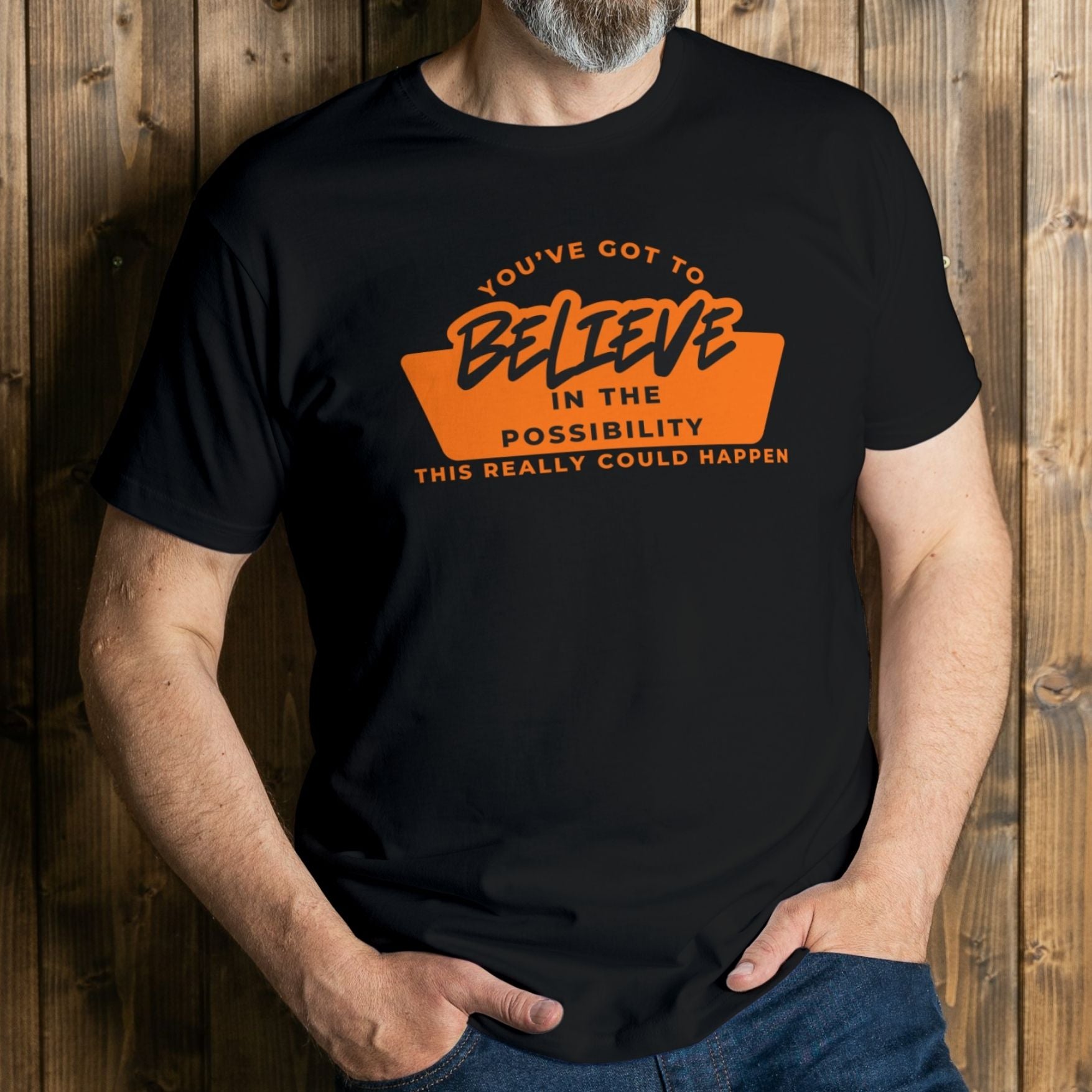 man wearing orange believe graphic tee