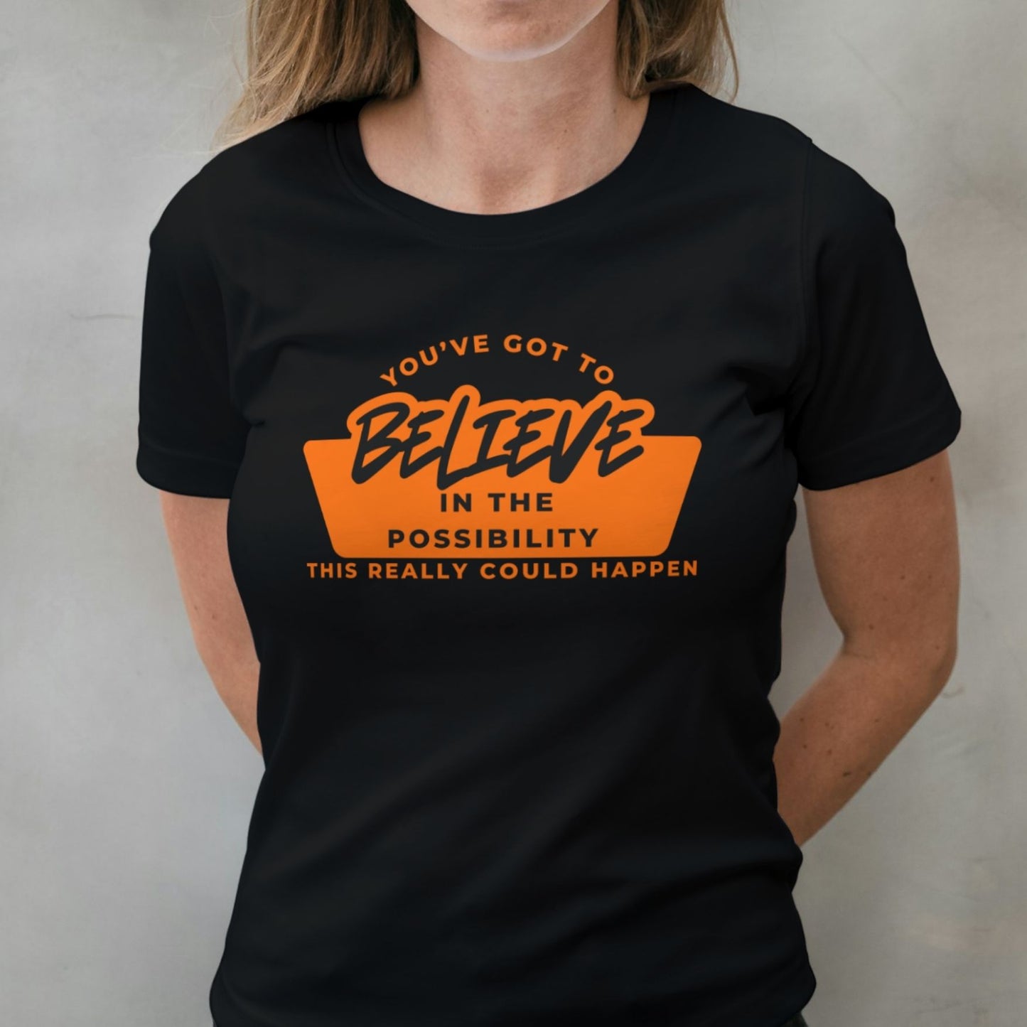 woman wearing orange believe graphic tee