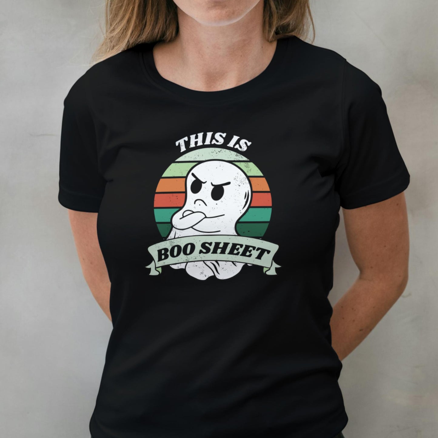 Person wearing a black t-shirt with a ghost graphic and text against a plain background