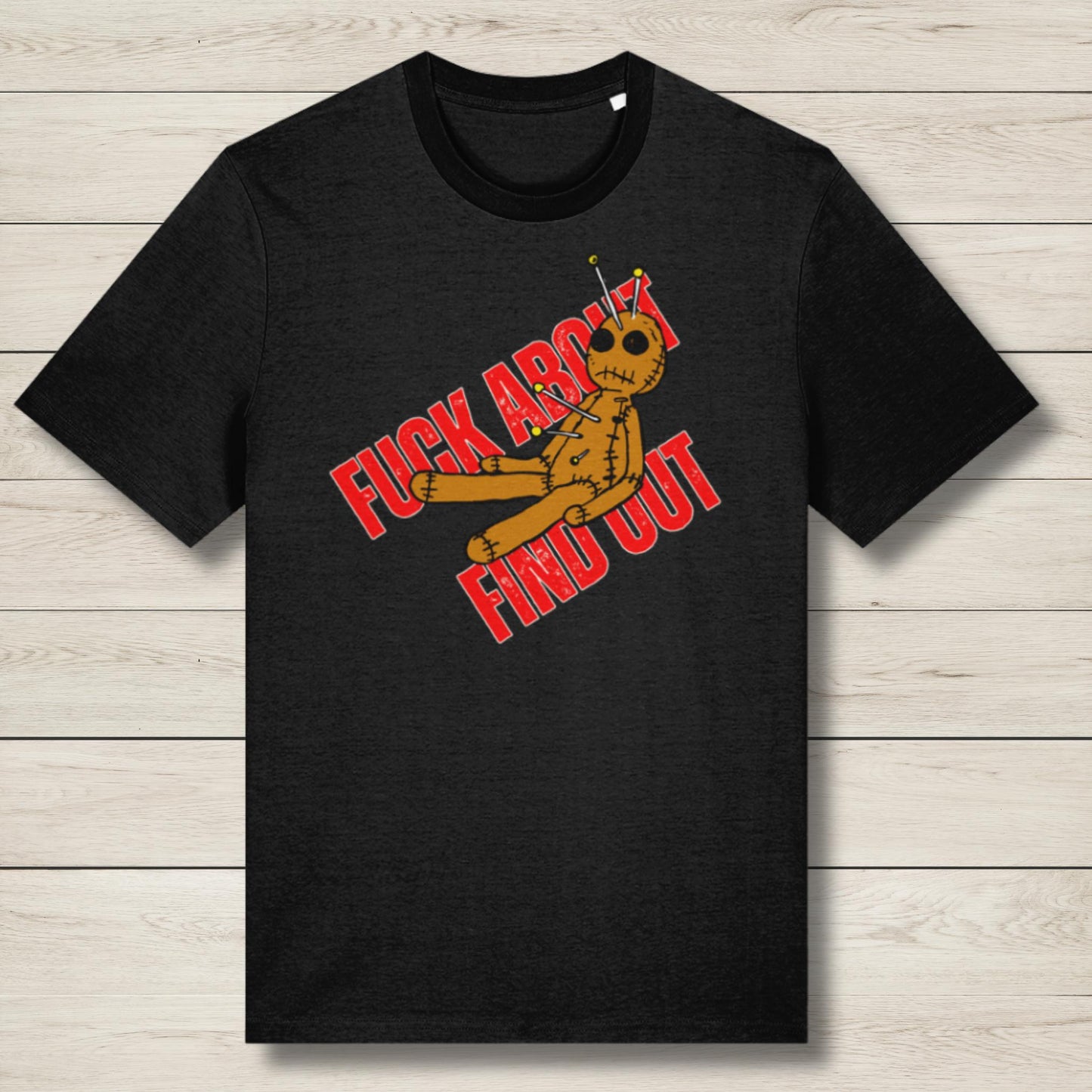 Black t-shirt with a graphic design featuring text and an alien figure on a wooden surface.