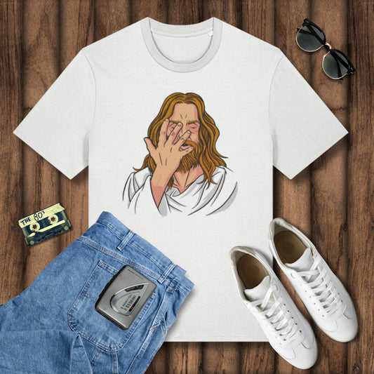 White t-shirt with a graphic design of a person covering their face, placed on a wooden surface with jeans, sneakers, and a cassette tape.