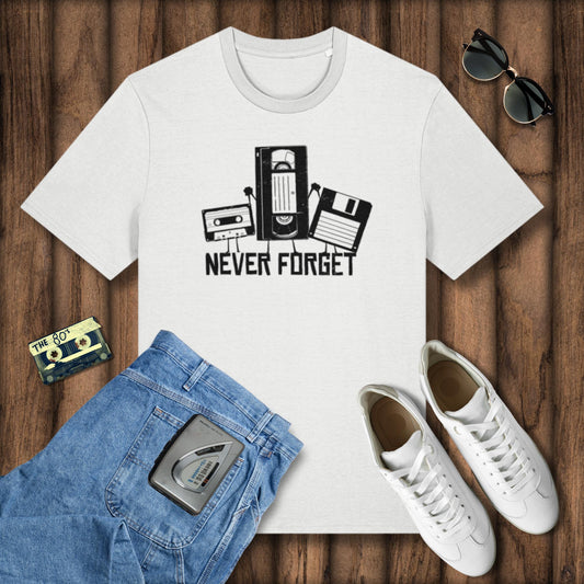 White t-shirt with 'Never Forget' graphic on a wooden surface with jeans, sneakers, and a cassette tape.