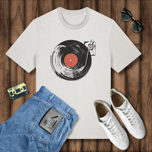 White t-shirt with vinyl record design, blue jeans, white sneakers, and sunglasses on a wooden surface.