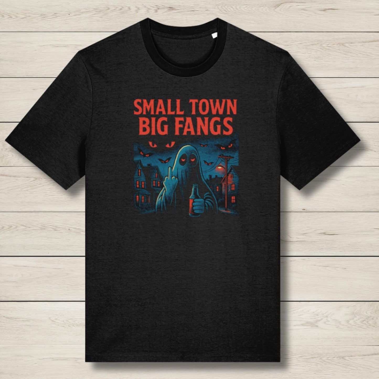 Black t-shirt with 'Small Town Big Fangs' graphic design on a wooden surface