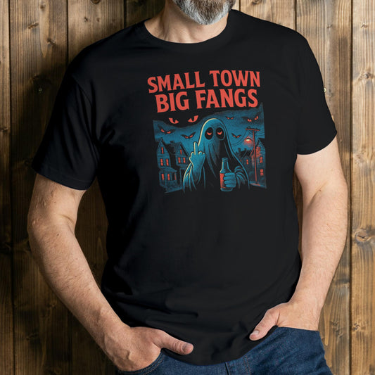 Person wearing a black t-shirt with 'Small Town Big Fangs' graphic design against a wooden background