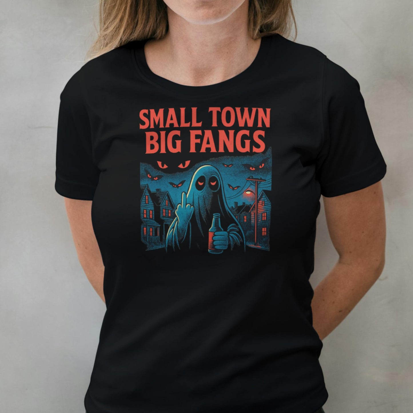 Person wearing a black t-shirt with 'Small Town Big Fangs' graphic design.