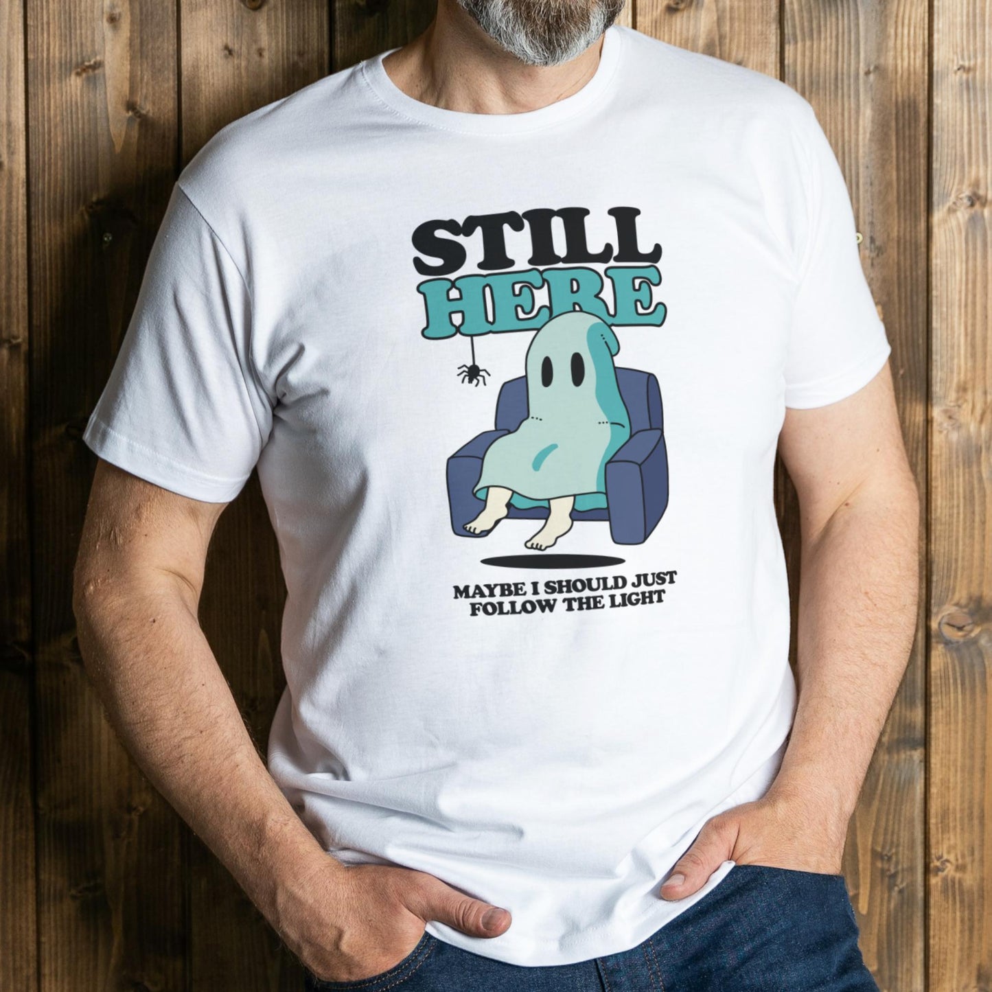 Person wearing a white t-shirt with a ghost graphic and text against a wooden background