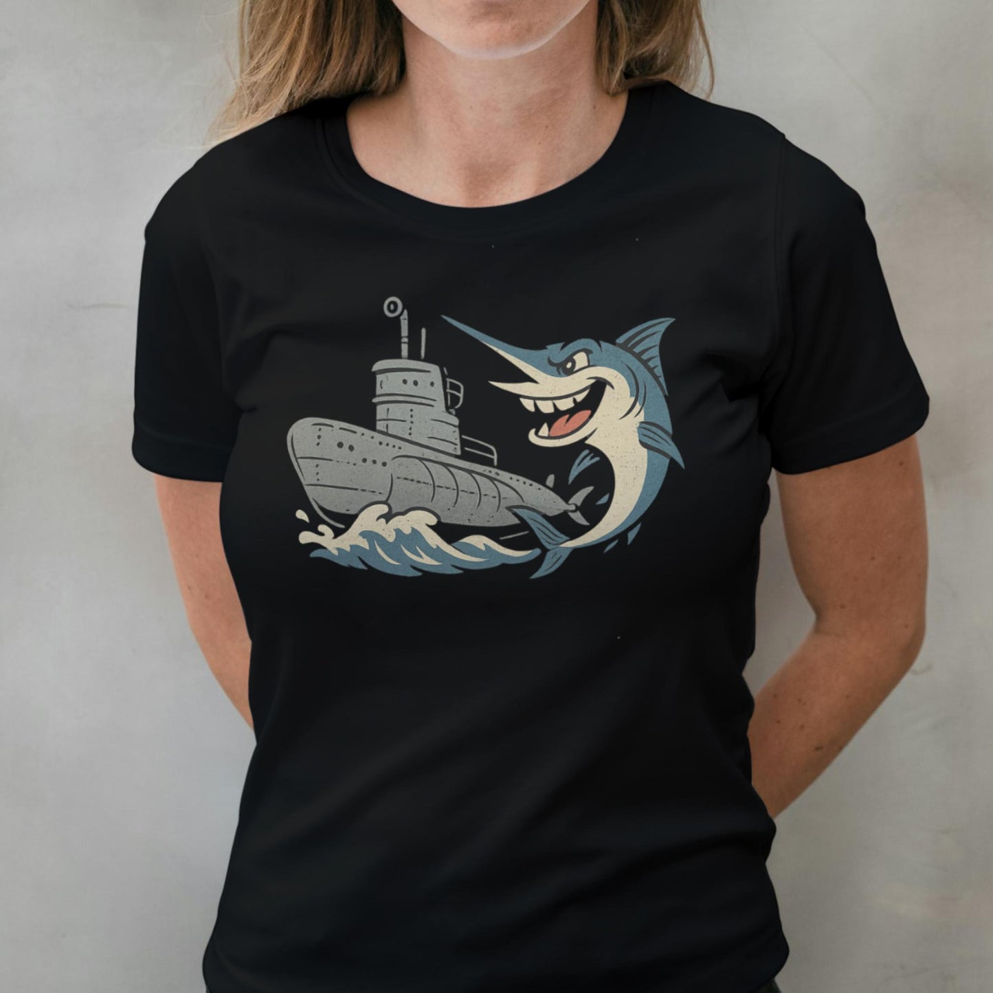 Person wearing a black t-shirt with a graphic design of a shark attacking a ship.