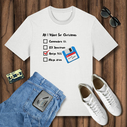 White t-shirt with retro gaming graphic, blue jeans, white sneakers, and cassette tape on a wooden surface.