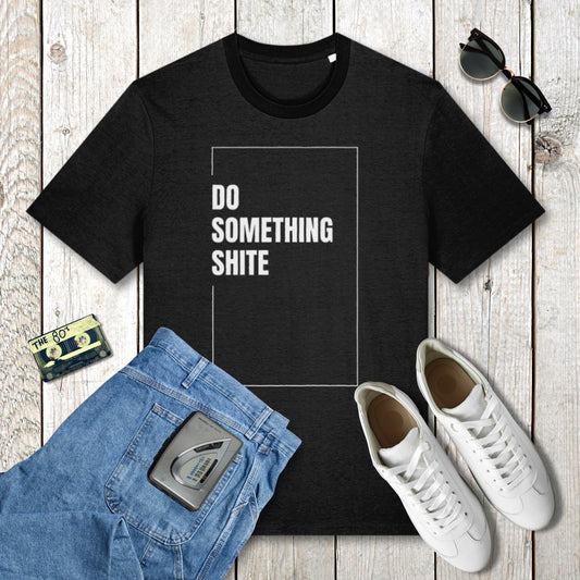 Black t-shirt with 'DO SOMETHING SHITE' text, blue jeans, white sneakers, and sunglasses on a wooden surface.