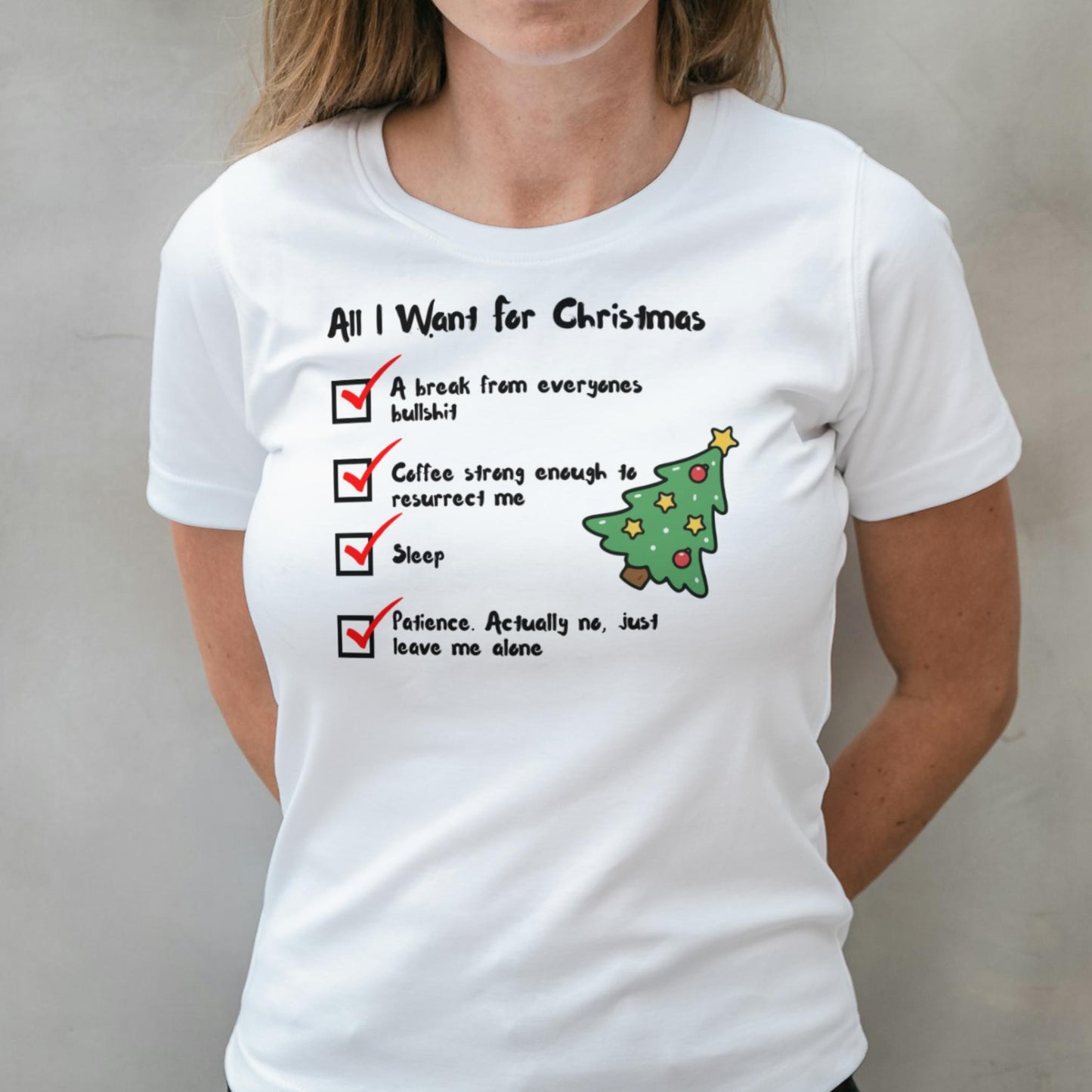 White t-shirt with Christmas-themed text and graphics worn by a person.