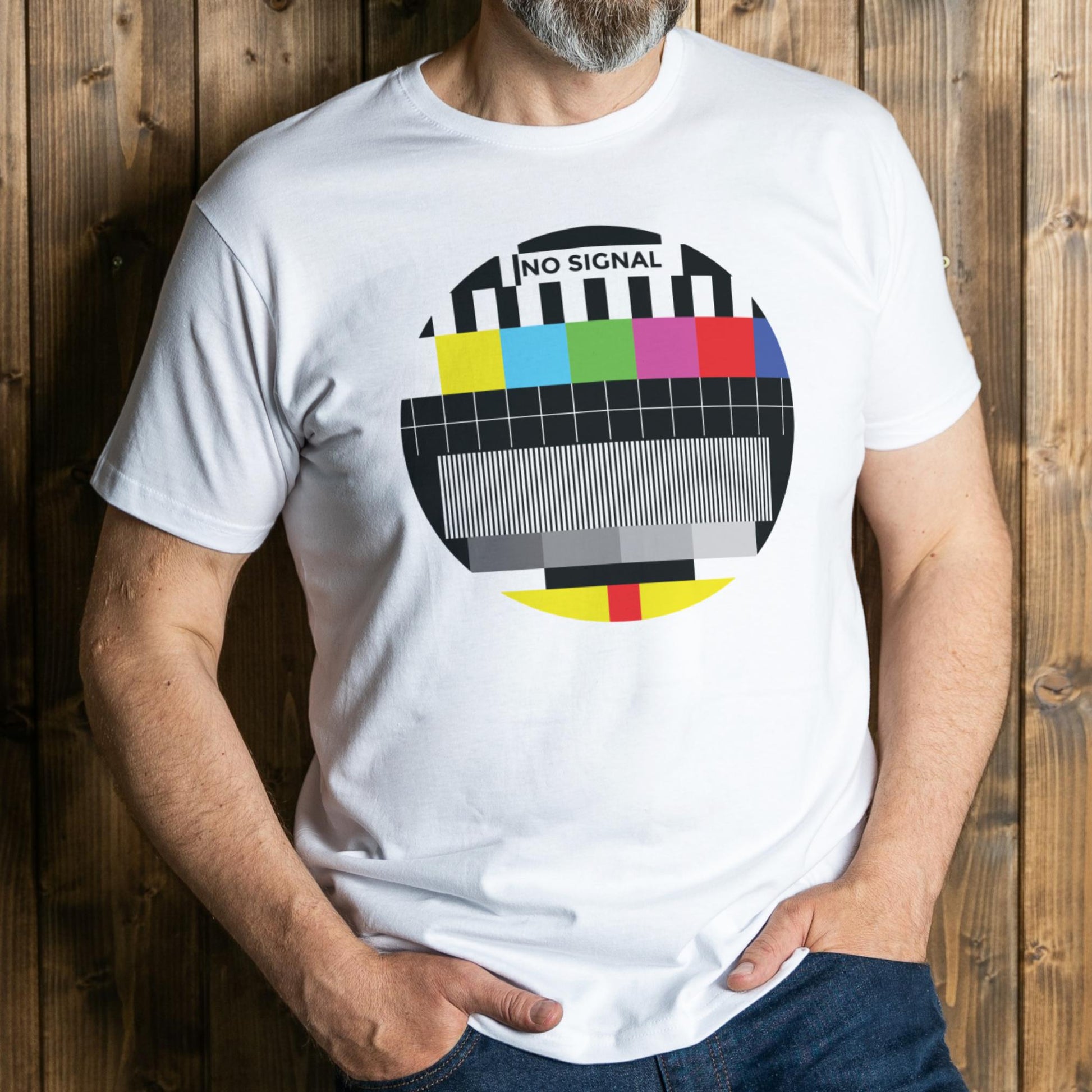 Person wearing a white t-shirt with a colorful 'No Signal' graphic against a wooden background