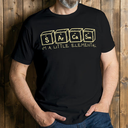 Person wearing a black t-shirt with 'Sarcasm is a little elemental' text design on a wooden background