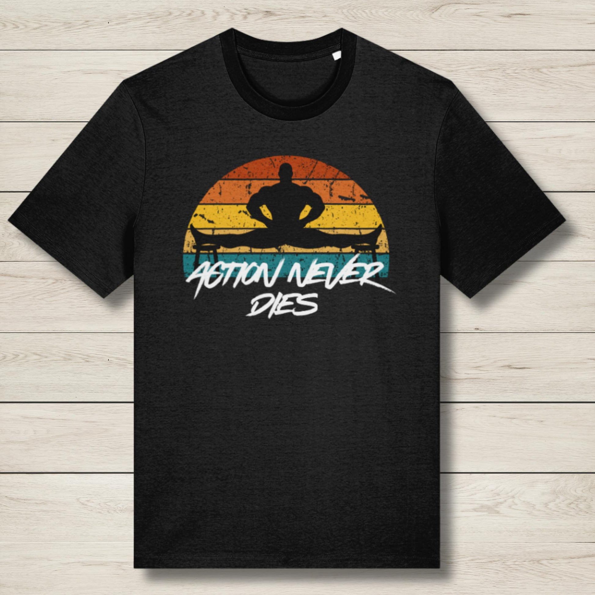Black t-shirt with a graphic design of a silhouette and 'Action Never Dies' text on a wooden surface