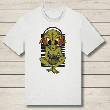 White t-shirt with a graphic of a green alien wearing headphones on a wooden surface