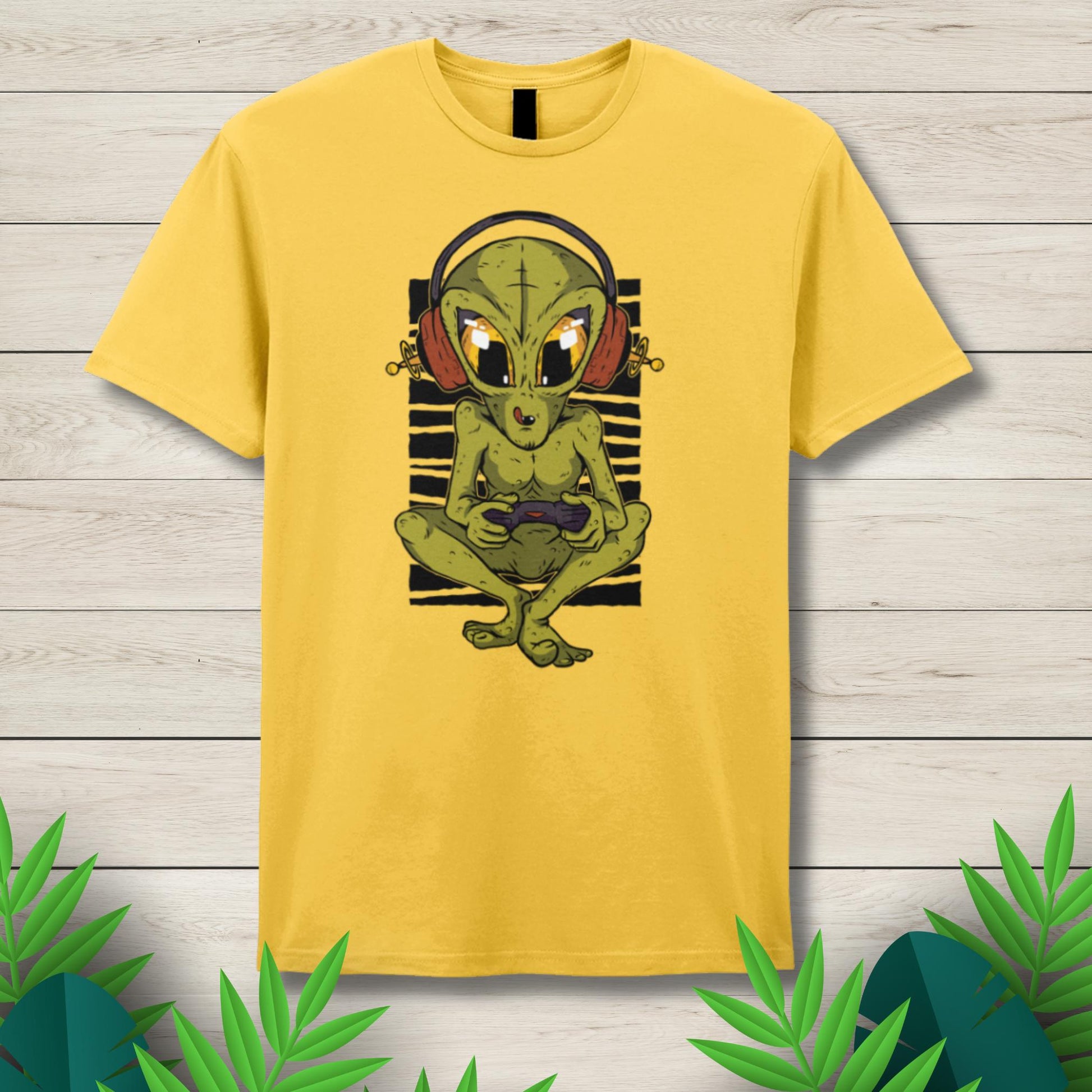Yellow t-shirt with an alien graphic on a wooden surface
