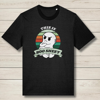 Black t-shirt with a ghost graphic and text on a wooden surface
