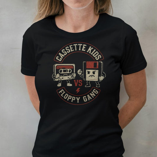 Person wearing a black t-shirt with 'Cassette Kids vs Floppy Gang' graphic design.