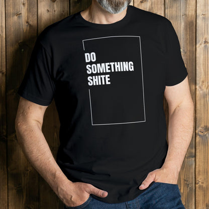 Person wearing a black t-shirt with 'DO SOMETHING SHITE' text against a wooden background