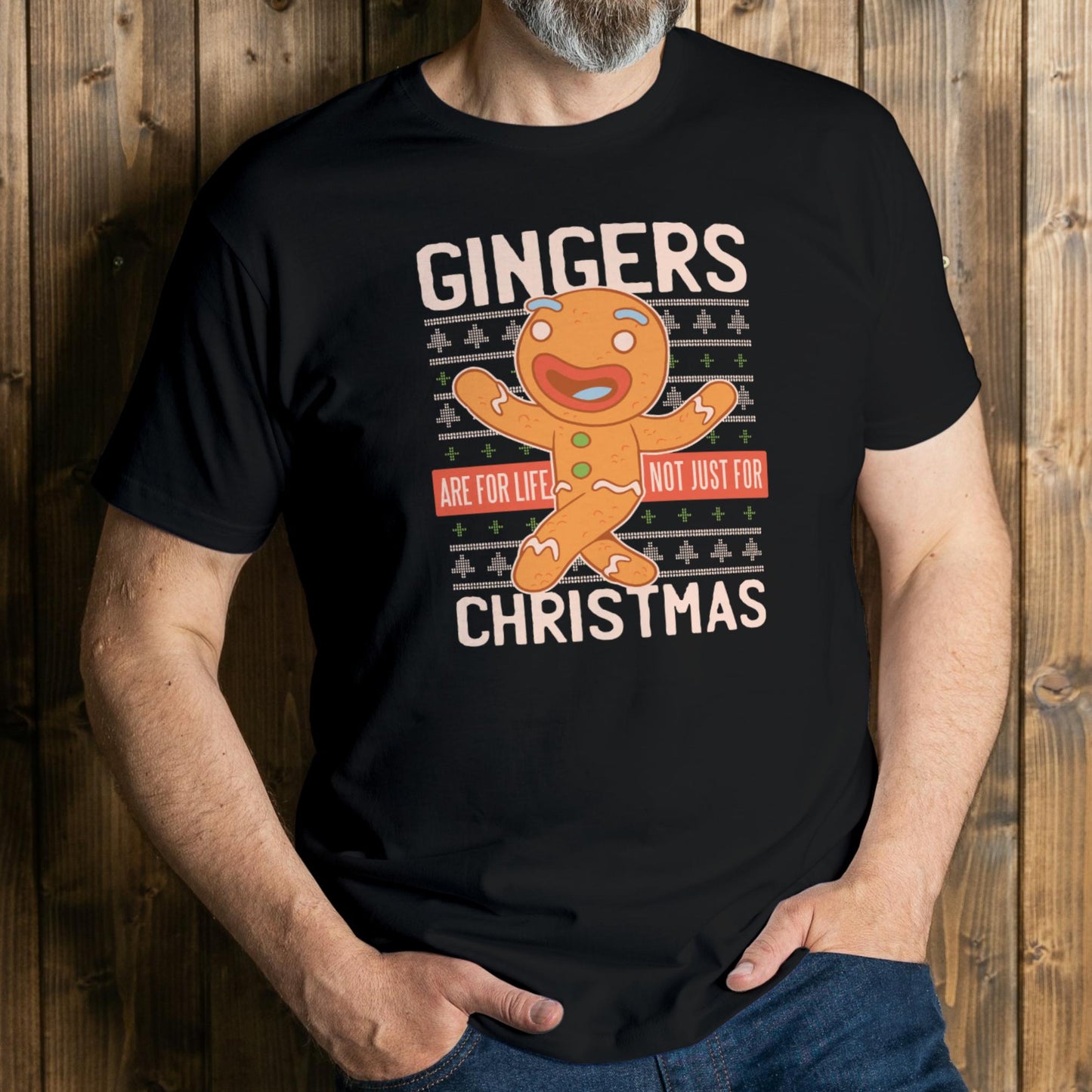 Person wearing a black t-shirt with a gingerbread man graphic and text against a wooden background