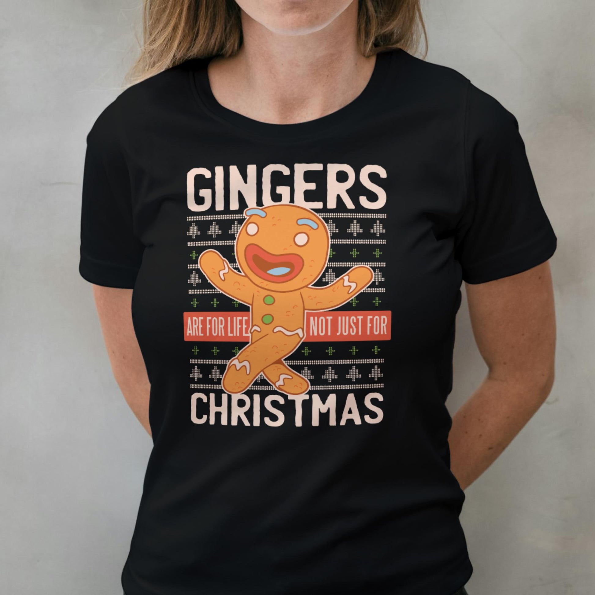 Person wearing a black t-shirt with a gingerbread man graphic and text.