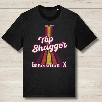 Black t-shirt with 'Top Shagger Generation X' design on a wooden surface